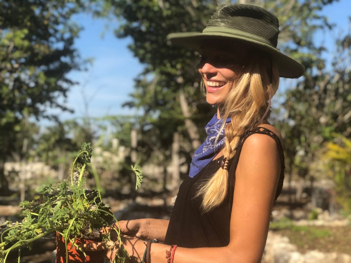 Fem smiling in the garden at Rancho Verde Tulum, gardening and workshops
