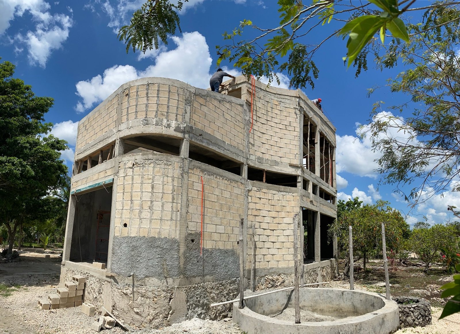 Workers laying concrete block walls on Casa Blanca, with the pool shell poured in front, Rancho Verde Tulum, Tulum, Mexico