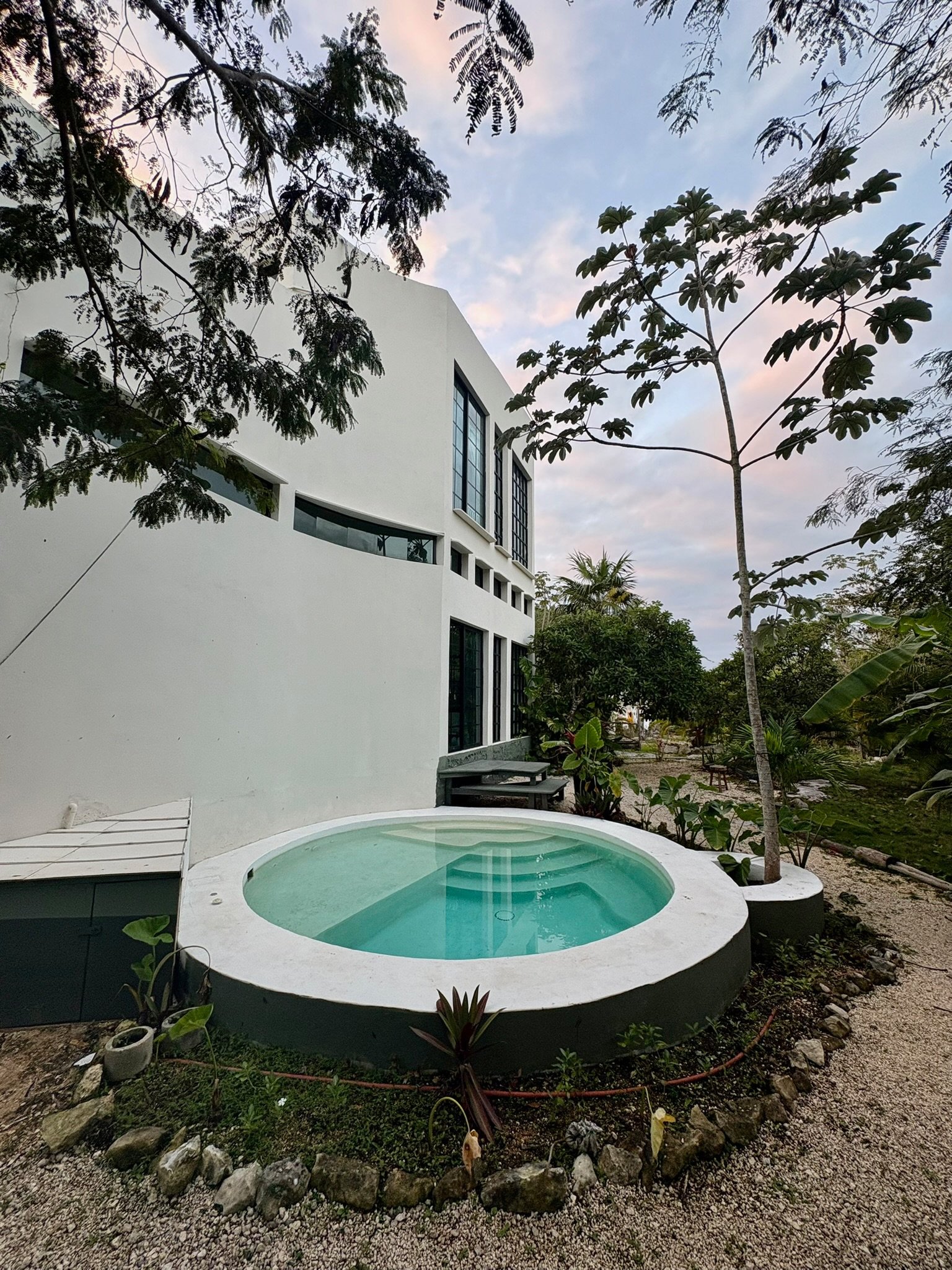 Casa Blanca exterior with the round plunge pool and garden at dusk, Rancho Verde Tulum, Tulum, Mexico