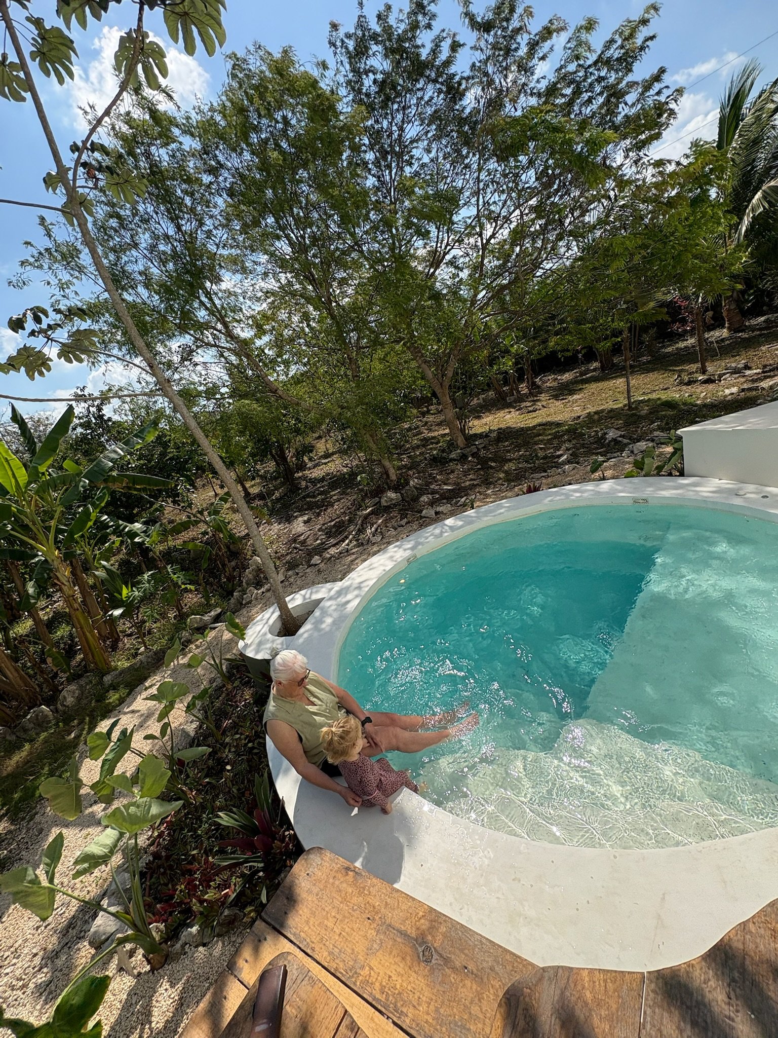 Finished round plunge pool, grandmother and child sitting at the edge, Rancho Verde Tulum, Tulum, Mexico