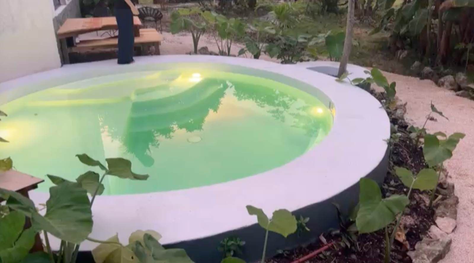 Round plunge pool lit up at dusk with underwater lighting and jacuzzi jets, Rancho Verde Tulum, Tulum, Mexico