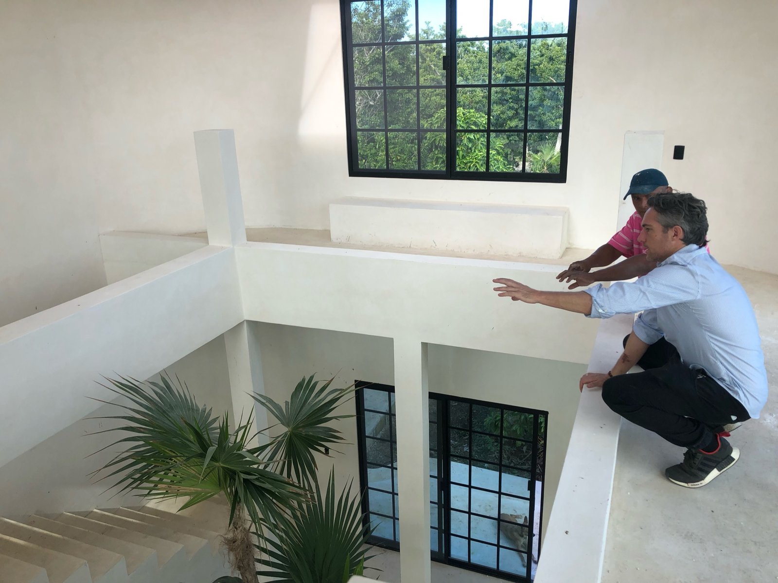 Founder Thomas and the builder looking over the finished stairwell and the construction below, Rancho Verde Tulum, Tulum, Mexico