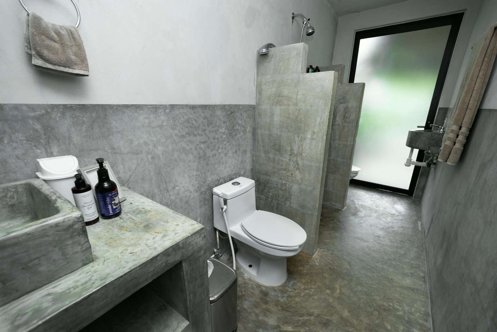 Polished concrete bathroom with a divider wall shower, toilet and frosted glass door, Rancho Verde Tulum, Tulum, Mexico
