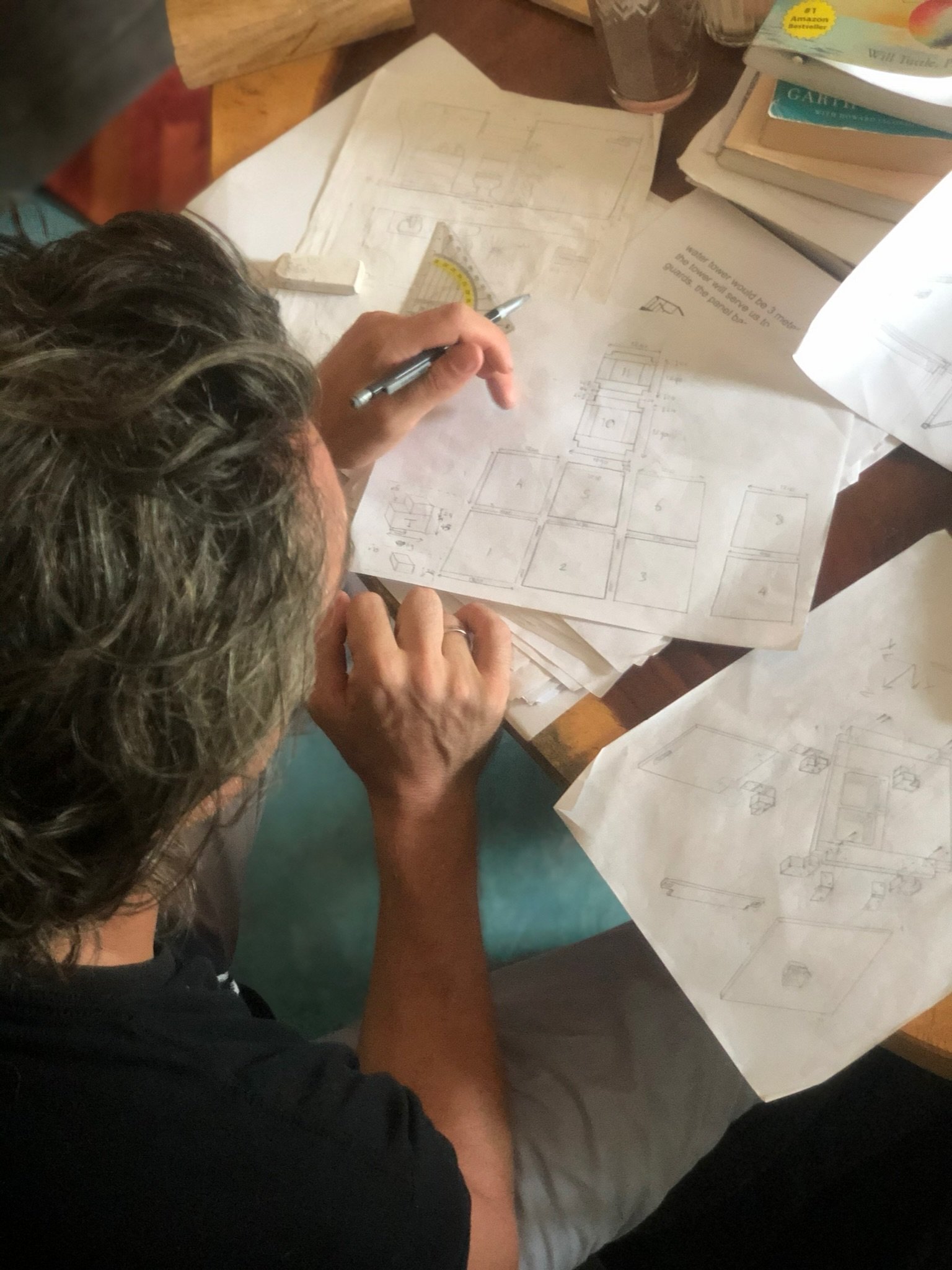 Founder Thomas drawing construction details with pencil and set square, Rancho Verde Tulum, Tulum, Mexico