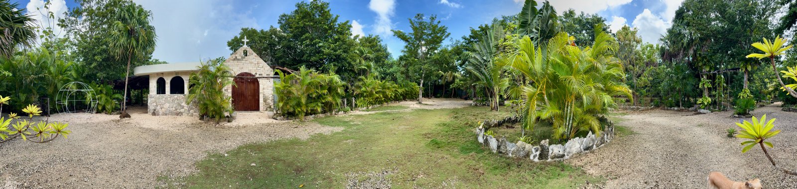 Panoramic view of Rancho Verde Tulum: the stone chapel, jungle garden and lawn of our self-built retreat sanctuary in Tulum, Mexico