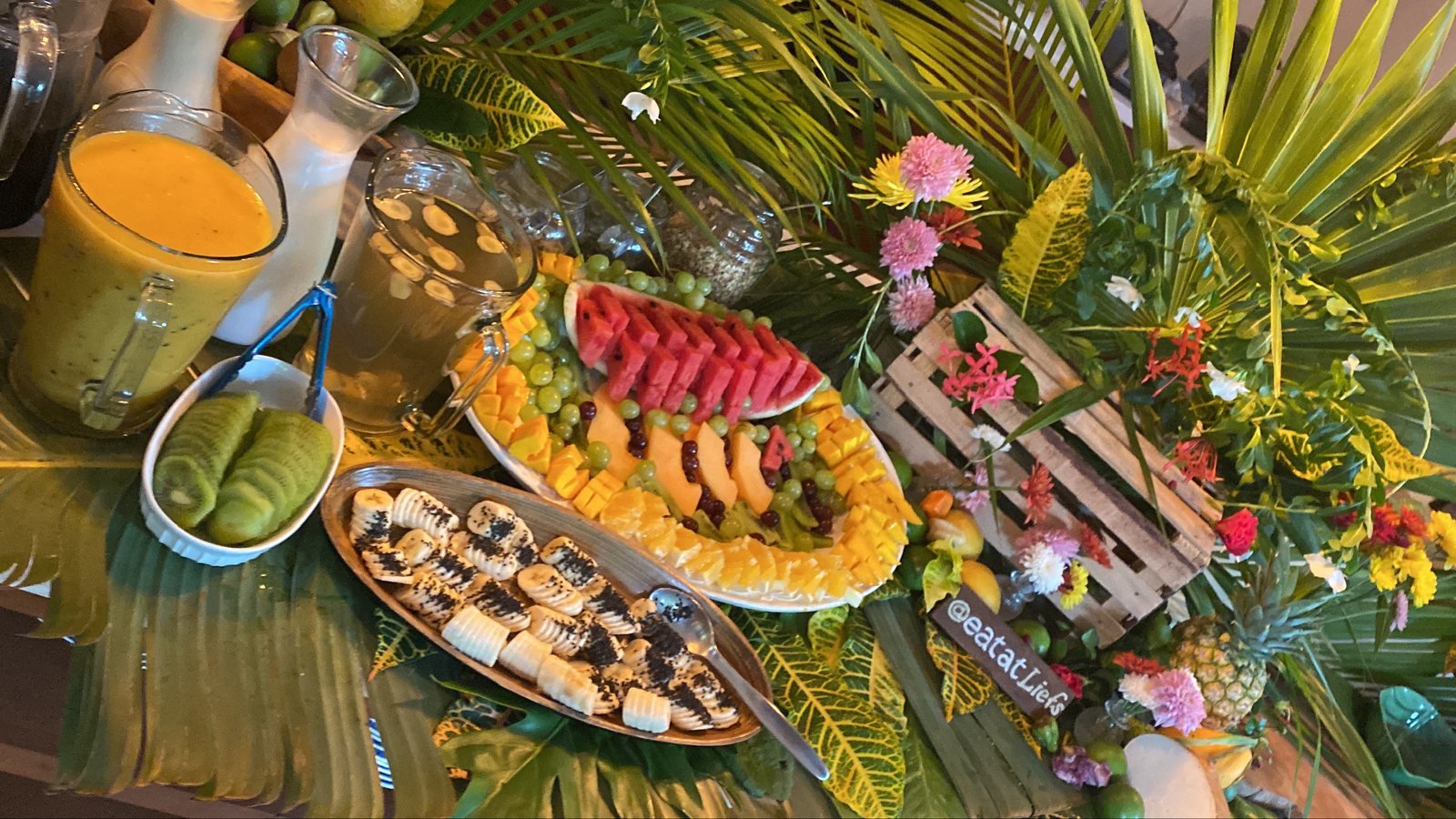 Evening fruit buffet with mango smoothie, melon, grapes and tropical leaves, vegan event catering by Liefs Tulum at Rancho Verde