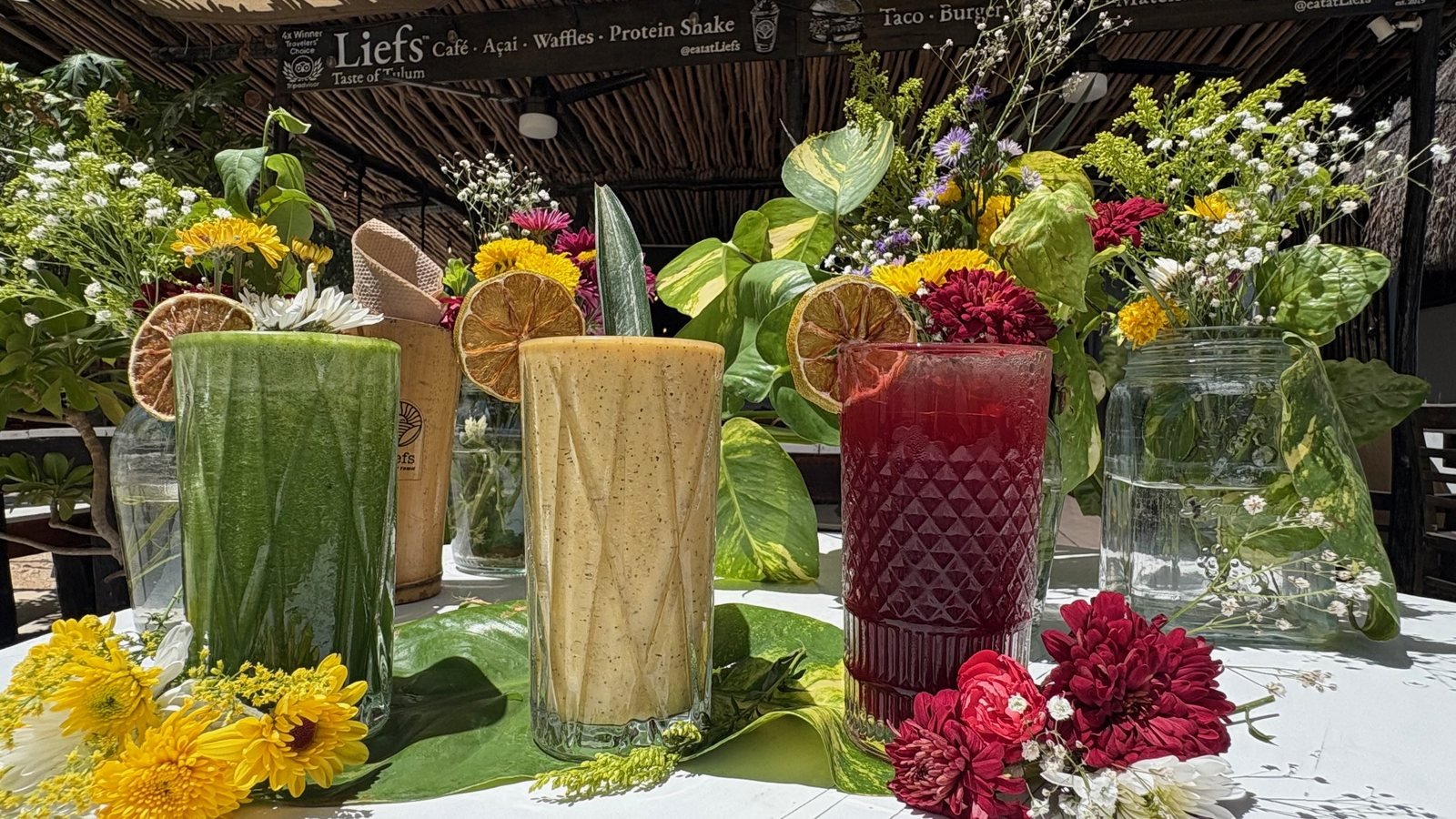 Green juice, mango smoothie and hibiscus water with dried citrus and fresh flowers at Liefs Tulum, vegan event catering by Liefs Tulum at Rancho Verde