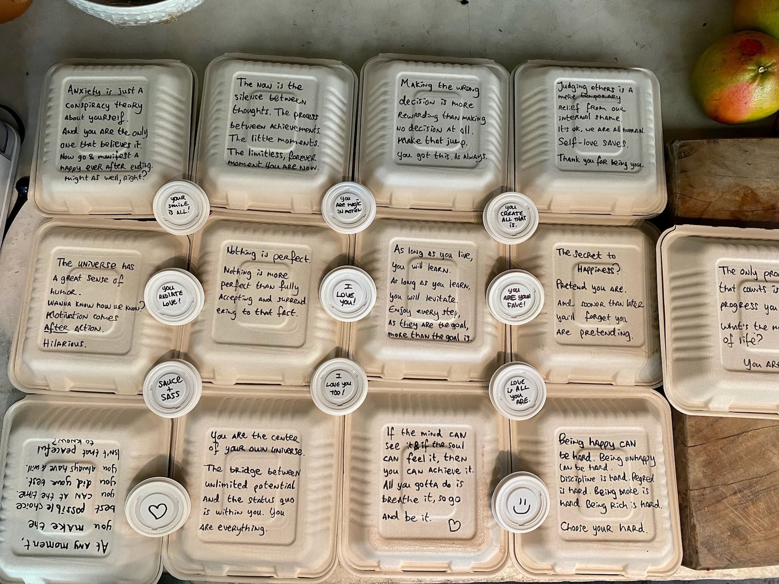 Retreat lunches in compostable boxes, each lid hand-written with a personal note, vegan event catering by Liefs Tulum at Rancho Verde