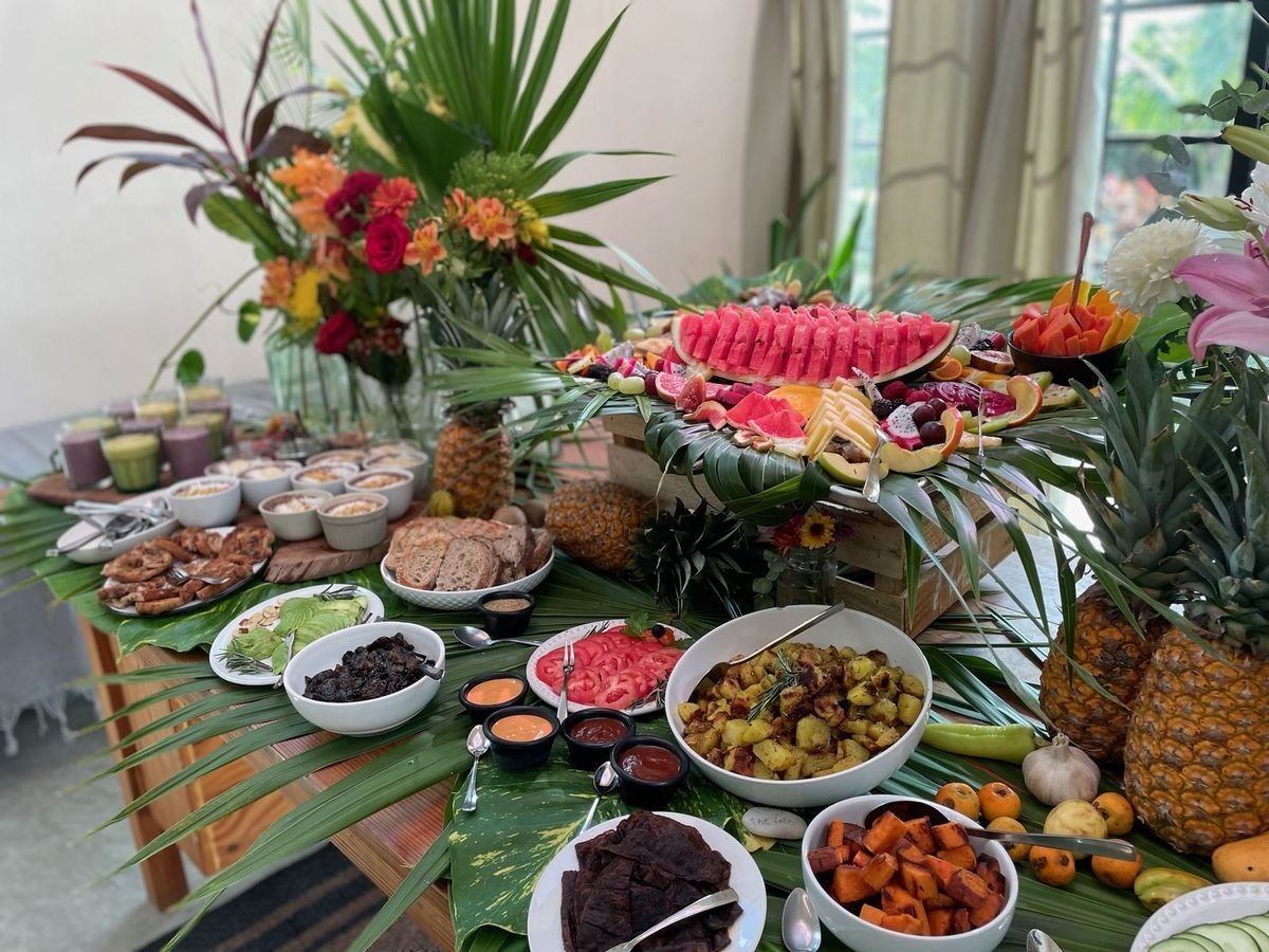 Tropical vegan brunch buffet with roasted potatoes, sweet potato, fruit and flowers at Rancho Verde Tulum