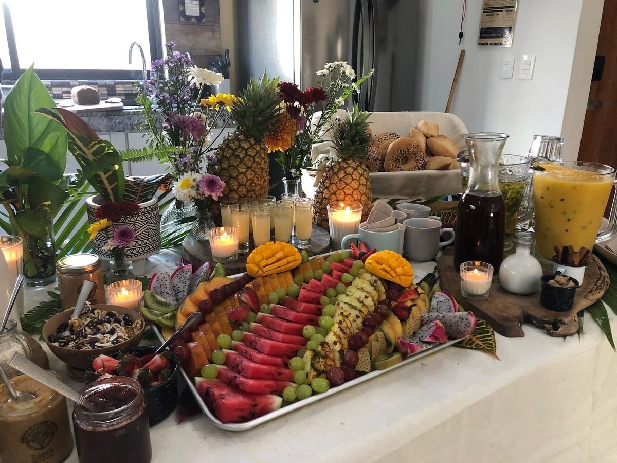 Vegan breakfast buffet with a tropical fruit platter, pineapples, fresh juices and candles by Liefs Tulum catering