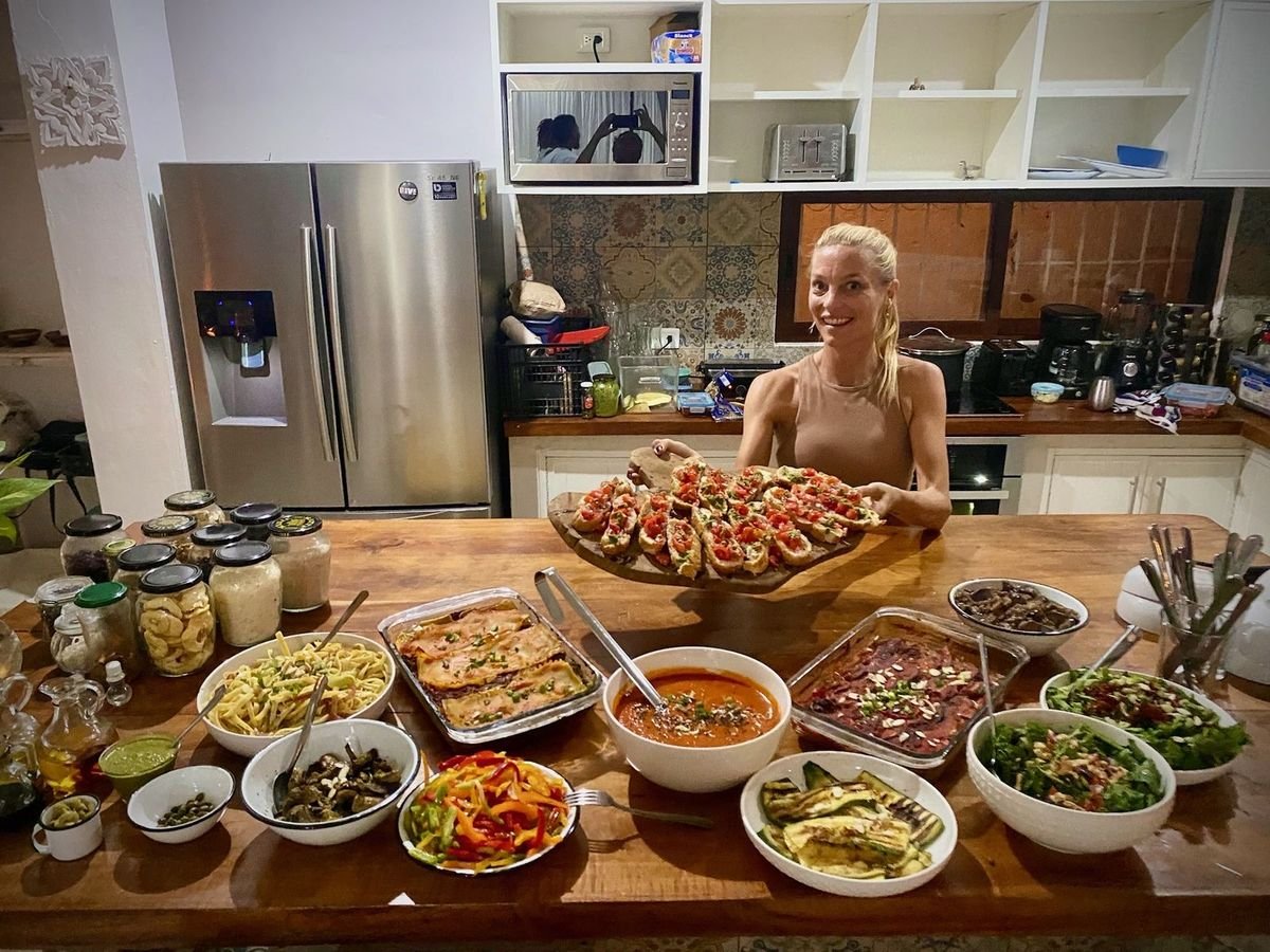 Liefs Tulum host presenting a vegan dinner spread with bruschetta, lasagna, soup and salads