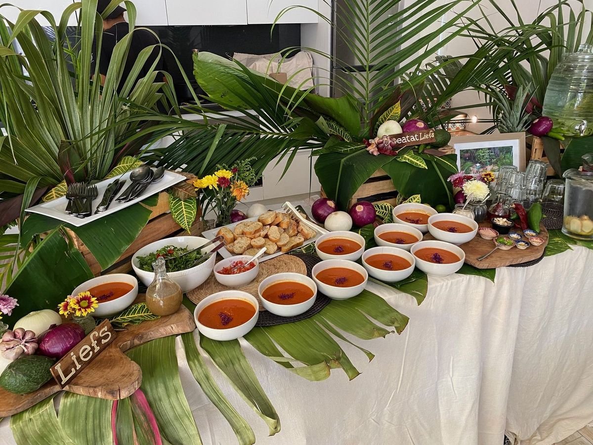 Vegan tomato soup lunch buffet with bread and salad, decorated with tropical leaves by Liefs Tulum