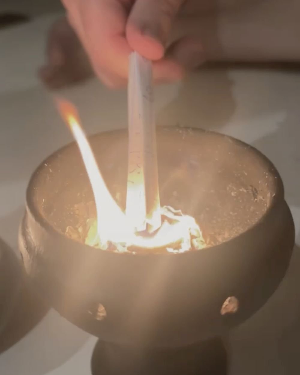 Letting-go ritual: burning a written note in a ceremonial bowl at Rancho Verde Tulum