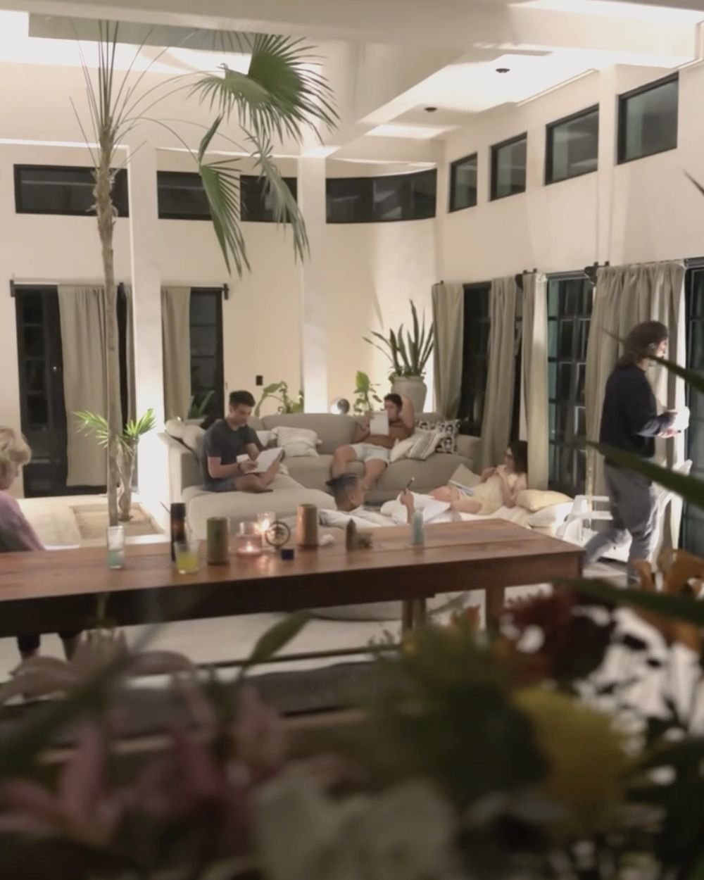 Retreat guests journaling in the evening living room at Rancho Verde Tulum