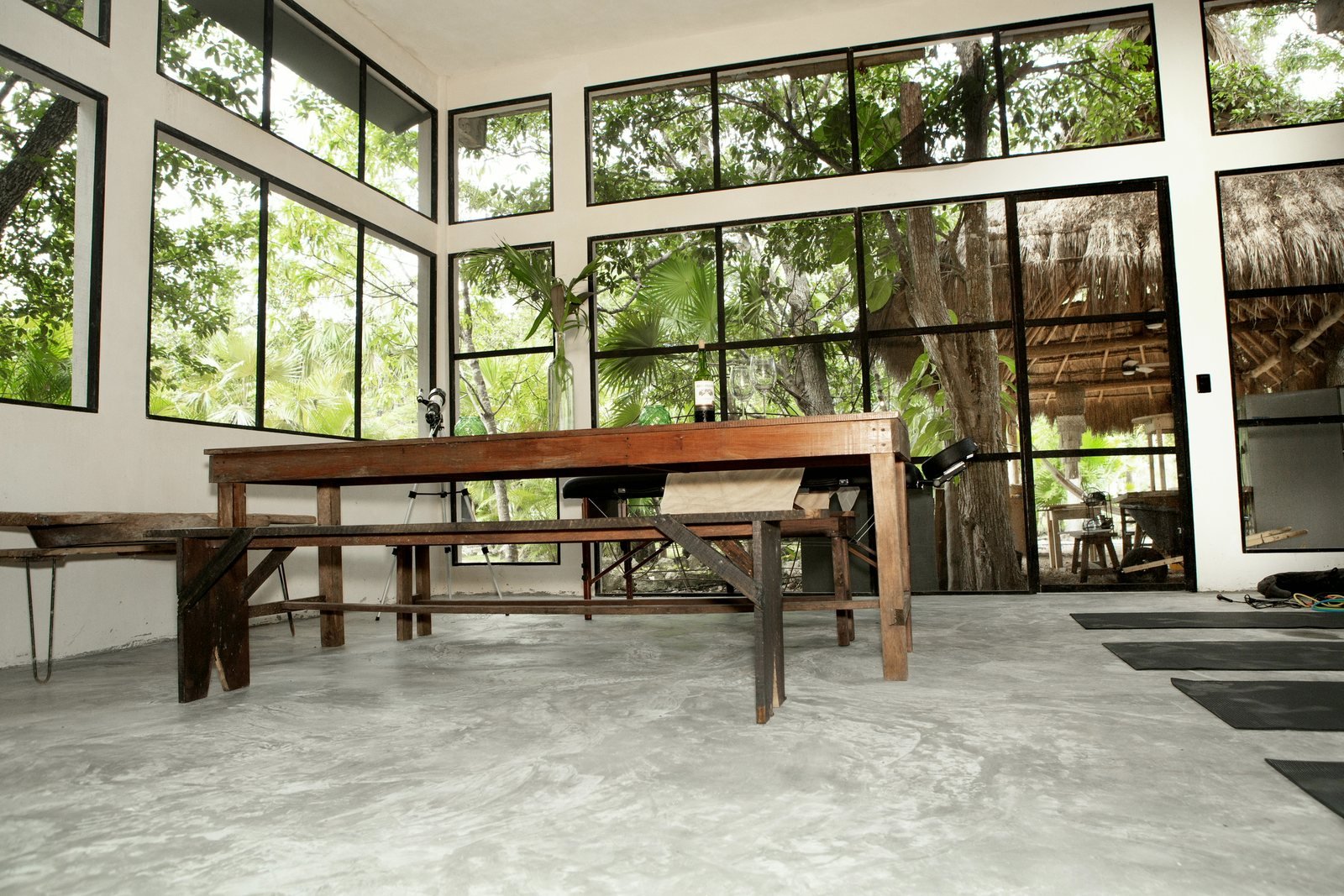 Sunroom with long wooden table and floor-to-ceiling jungle windows, The Family House, Airbnb at Rancho Verde Tulum