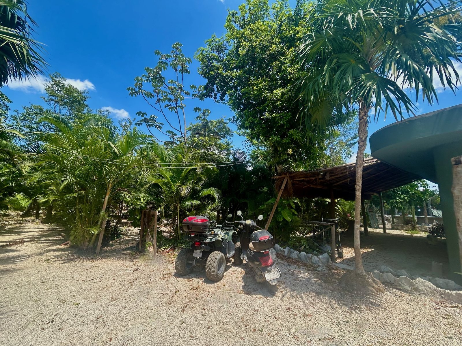 On-site parking under the palms with ATV and scooter, Rancho Verde Tulum