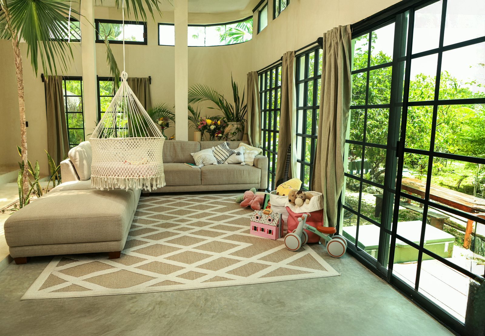 Family-friendly Villa living room with hanging crib, sofa and garden windows, Airbnb at Rancho Verde Tulum