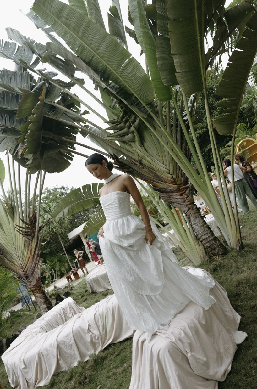 Bride in a white gown under traveler's palms in the ceremony lounge at Rancho Verde Tulum