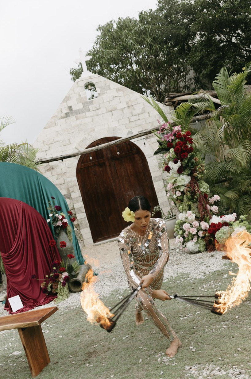 Fire dancer performing in front of the stone chapel at a wedding at Rancho Verde Tulum