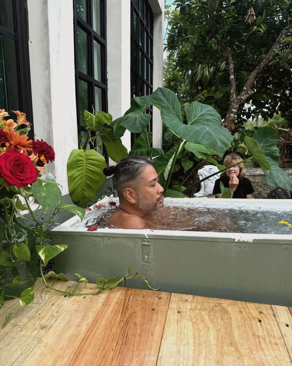 Guest in a garden ice bath cold plunge at Rancho Verde Tulum