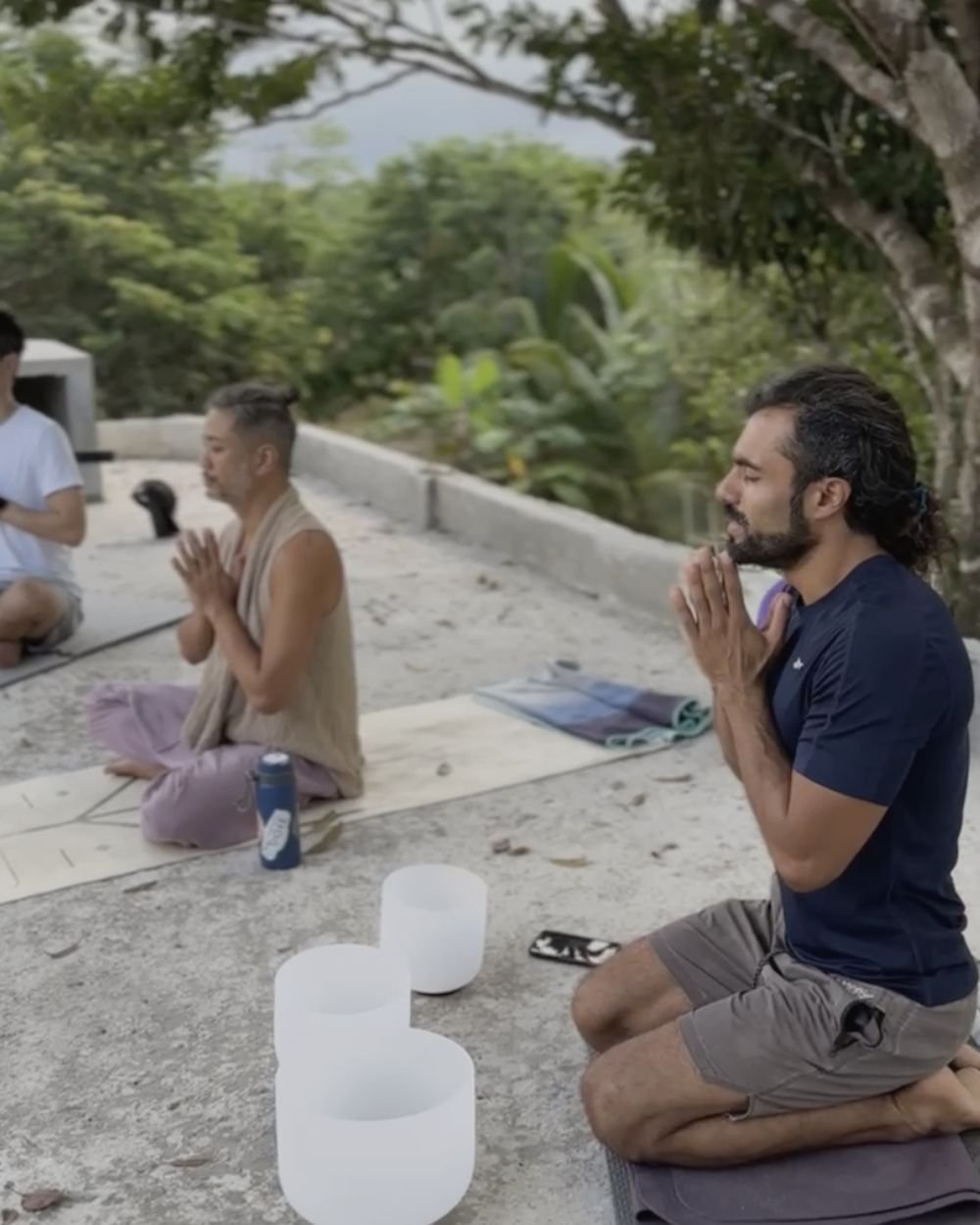 Retreat guests meditating beside crystal singing bowls on the rooftop at Rancho Verde Tulum