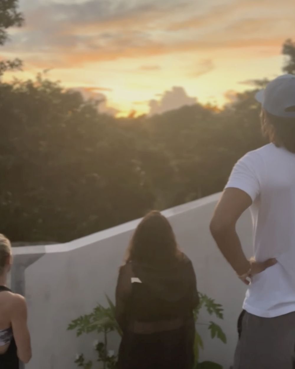 Retreat guests watching the sunset over the jungle from the Rancho Verde Tulum rooftop