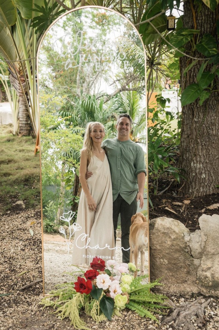 Founders Thomas and Fem reflected in the floral welcome mirror at Rancho Verde Tulum